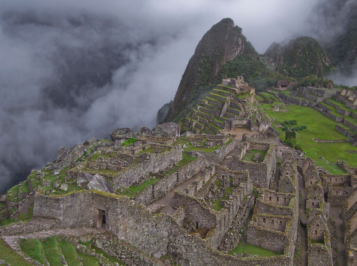 Tereny Machu Picchu otoczone mgłą i górami o wschodzie